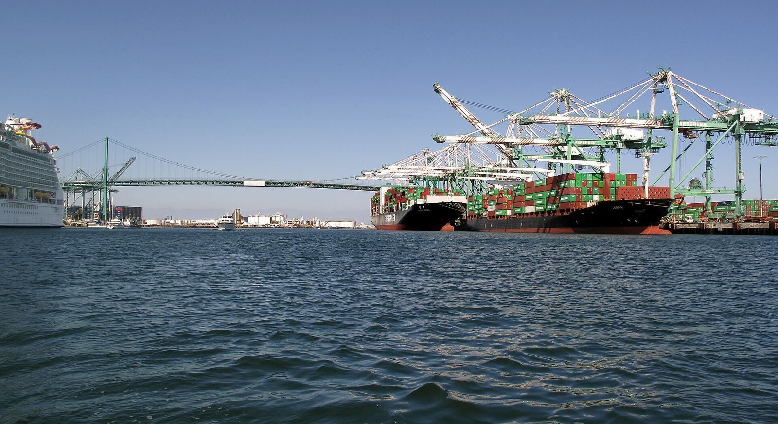 Container ships being worked by gantry cranes at a marine terminal.